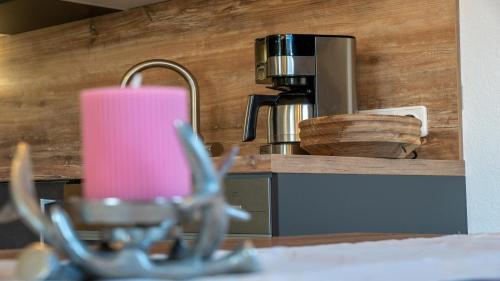 a kitchen counter with a pink candle and a coffee maker at Stubaier Bauern Appartement in Telfes im Stubai