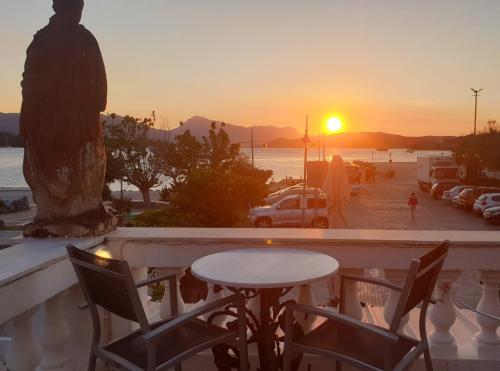 a table and chairs on a balcony watching the sunset at Dionysos Hotel in Poros