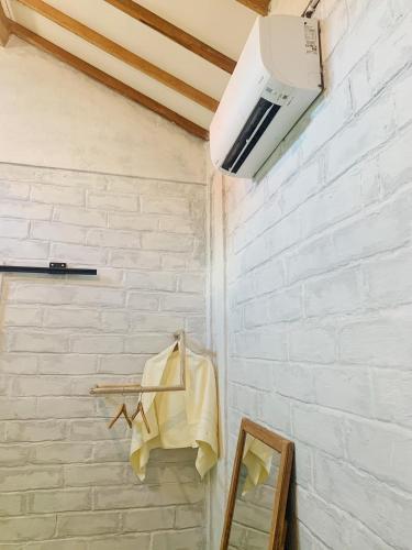 a white brick wall with a towel hanging on a rack at KALINDA HOMEY in Karimunjawa