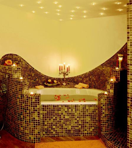 a bathroom with a bath tub with candles on it at Köhlers Forsthaus Wellness & Genuss Hotel in Aurich