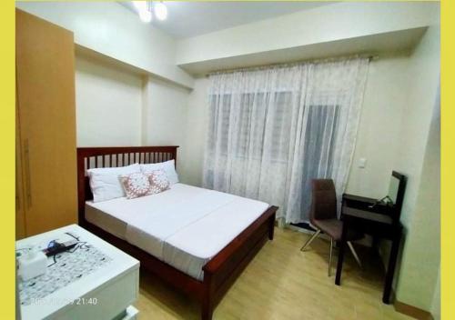 a bedroom with a bed and a desk and a window at Lafayette Park Square,Iloilo Business Park Condo P in Iloilo City