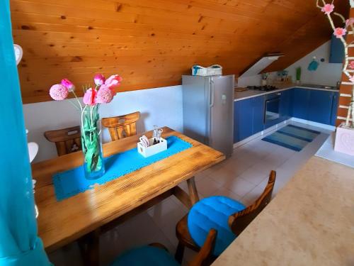 una cocina con una mesa con un jarrón de flores. en Kuća za odmor Delak, en Fužine