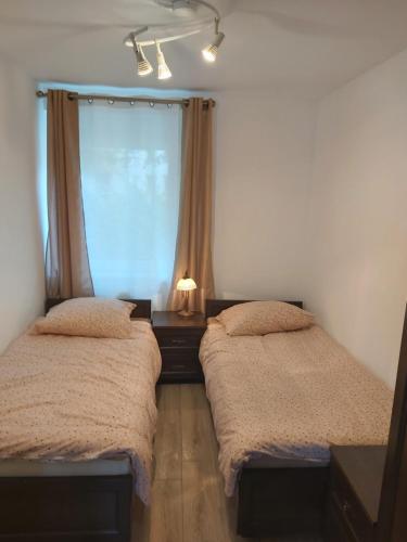 dwa łóżka pojedyncze w pokoju z oknem w obiekcie Apartament 1 SUPER VIP Królewiecka centrum w mieście Mrągowo