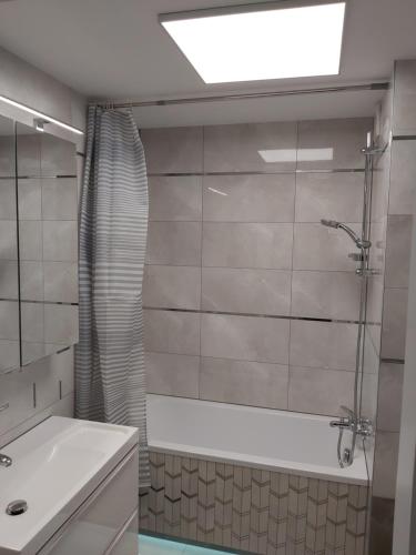 y baño con bañera, lavamanos y ducha. en Apartment for you 1 Królewiecka 40B, en Mrągowo