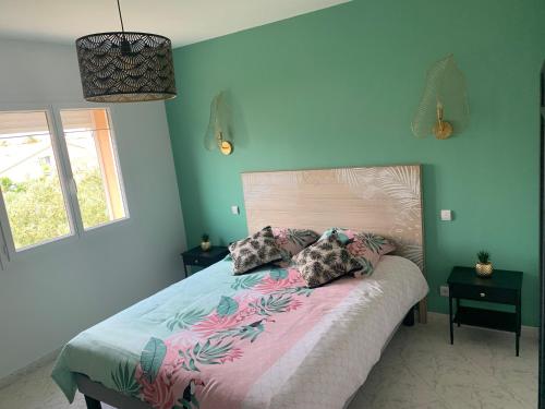 - une chambre avec un grand lit aux murs roses et bleus dans l'établissement Villa familiale Saint Cyprien plage, à Saint-Cyprien