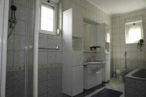 a bathroom with a sink and a shower and a toilet at Apartmani Delač in Vodice
