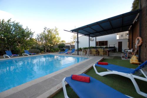 una piscina con 2 sillas y una mesa en Villa Torrent, en Puerto de Alcudia