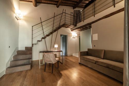 a living room with a staircase and a table and a couch at Relais Della Rovere in Colle Val D'Elsa
