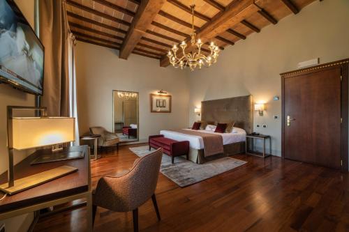 um quarto com uma cama e uma sala de estar em Relais Della Rovere em Colle Val D'Elsa