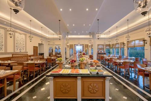 a dining room with tables and chairs in a restaurant at Trident Udaipur in Udaipur