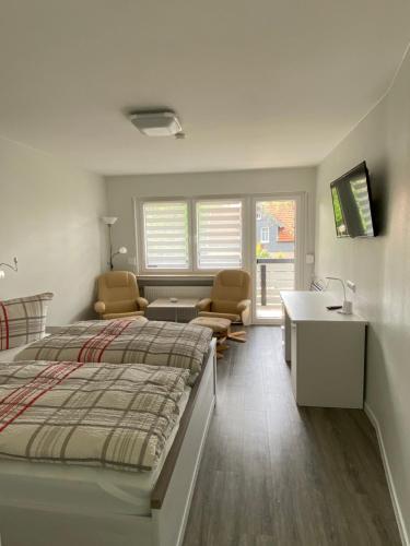 a bedroom with a bed and a desk and chairs at Hotel Braunlage in Braunlage