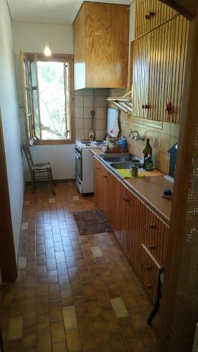 a kitchen with wooden cabinets and a tile floor at Phaedra's Mesonet in Málta