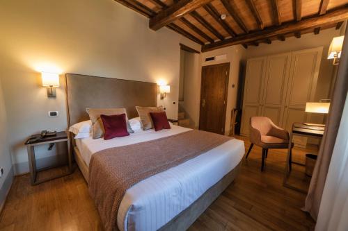 a hotel room with a large bed and a desk at Relais Della Rovere in Colle Val D'Elsa