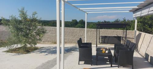 a patio with a table and chairs under a canopy at Apartment Stanko in Ližnjan