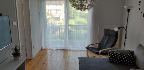 sala de estar con silla y ventana grande en Apartments Justin, en Bled