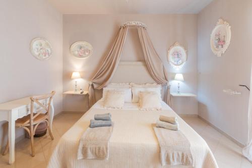 una camera bianca con un letto con due cuscini sopra di Bed and Breakfast Melina a Casarano