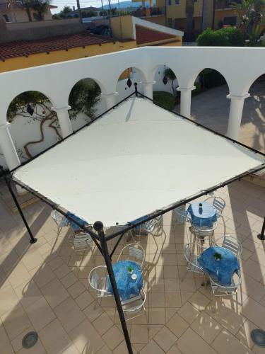 a large white table and chairs on a patio at Hotel Villa Ionia in Avola