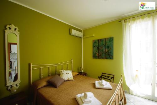 テッラジーニにあるAl Duomo Appartamenti Terrasiniの緑の壁のベッドルーム1室(窓付)
