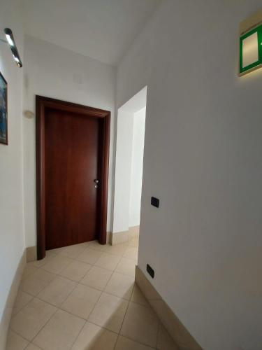 a hallway with a wooden door and a tile floor at Hotel Villa Ionia in Avola