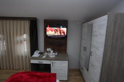 Una televisión o centro de entretenimiento en Hotel Happy