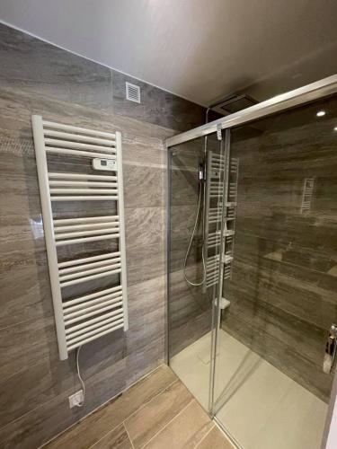 une douche avec une porte vitrée dans une salle de bain dans l'établissement Maxima Sunset, à Sainte-Maxime
