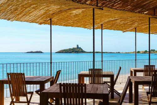 a group of tables and chairs with a view of the ocean at Sant Efis Hotel in Pula