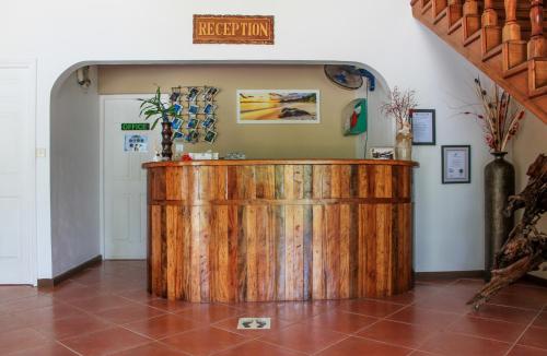 a wooden bar in a room with a sign on the wall at L'Habitation Cerf Island in Cerf Island