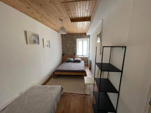 une chambre avec deux lits et une étagère dans l'établissement charmante maison de village renovée, à Bazoges-en-Pareds