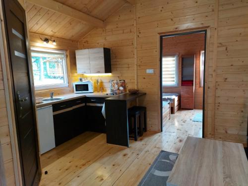 a kitchen in a log cabin with a table at DOMKI , Pokoje gościnne Ustronie in Zwierzyniec