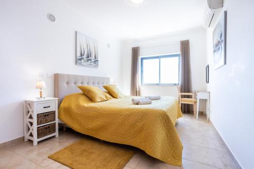 una camera da letto bianca con un letto e un tavolo di Quinta das Palmeiras - Monchique views a Lagos