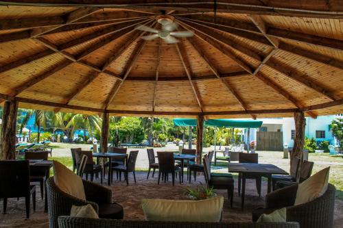a restaurant with tables and chairs under a wooden umbrella at L'Habitation Cerf Island in Cerf Island