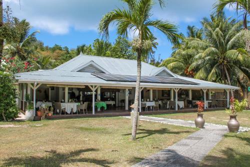 a house with a palm tree in front of it at L'Habitation Cerf Island in Cerf Island