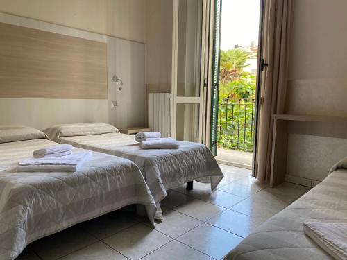 1 Schlafzimmer mit 2 Betten und einem großen Fenster in der Unterkunft Hotel Due Giardini in Mailand