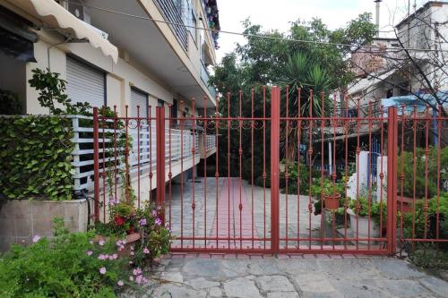 a red gate in front of a house with flowers at Iris Room in Metamorfosi