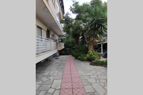 a pink tile walkway in front of a building at Iris Room in Metamorfosi
