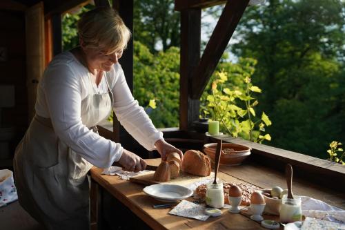 a woman standing in a kitchen preparing food on a table at HIS-a za 2 in Dragatuš
