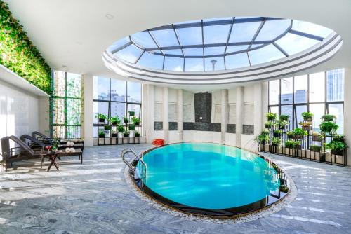una gran piscina en un edificio con techo de cristal en Brilliant Hotel, en Da Nang