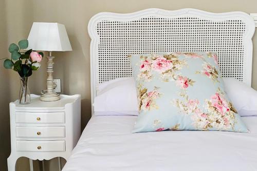 a white bed with a pillow and a lamp on a night stand at Casa Vacacional Galiana in Avilés