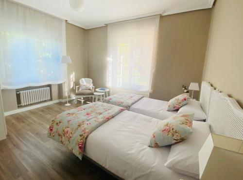 a bedroom with a large white bed with two pillows at Casa Vacacional Galiana in Avilés