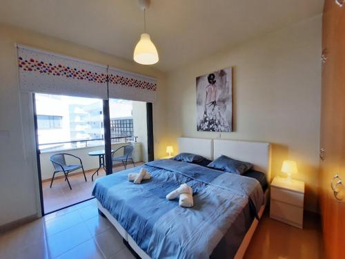 ein Schlafzimmer mit einem blauen Bett und einem Balkon in der Unterkunft Albert's apartments in Larnaka