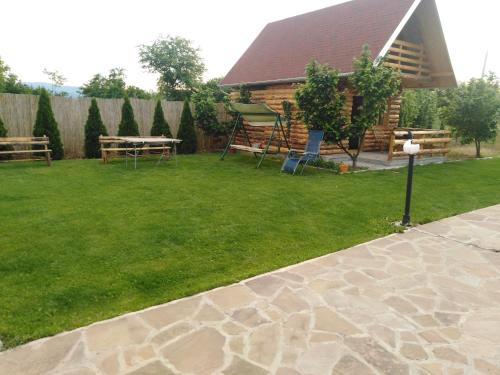 a yard with chairs and a table and a fence at Vila Viktori in Pirot