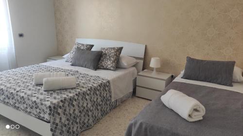 1 dormitorio con 2 camas con sábanas grises y grises en Casa Angela, en Salerno
