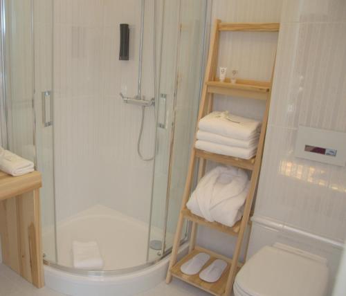 a bathroom with a shower and a toilet and towels at Willa Sepia SPA in Wisła