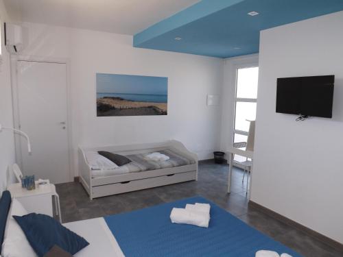 a living room with a bed and a flat screen tv at La Dimora di Ntò in Villaggio Azzurro