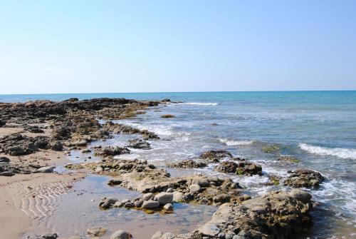 a beach with some rocks and the ocean at La Dimora di Ntò in Villaggio Azzurro