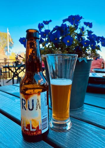 a bottle of beer and a glass on a table at Bergsgården Hotell & Konferens in Bergsgården