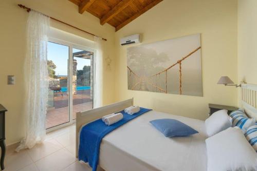 - une chambre avec un lit et une grande fenêtre dans l'établissement Cathrin Beachfront Villa, à Plimmiri
