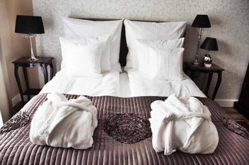 a bedroom with a bed with two white towels on it at Willa Sepia SPA in Wisła