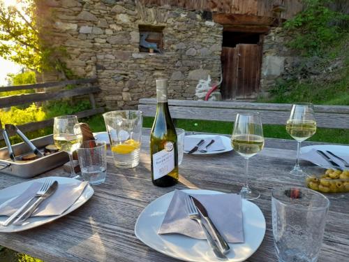 una mesa de madera con una botella de vino y copas en Reinwalds Almhütte, en Millstatt