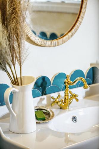 a white sink with a vase and a mirror at Villa Nautilus in Áfra